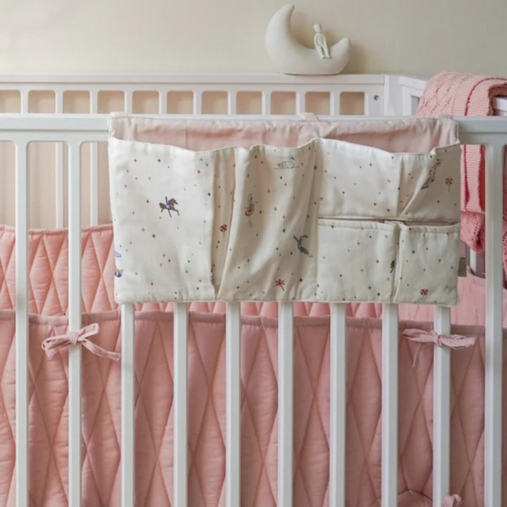 Bedzak met Carousel print aan het bedje in een rustige babykamer